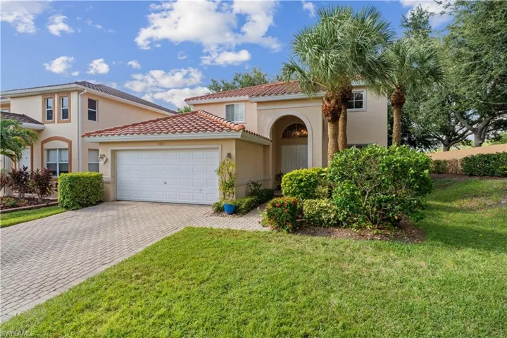 Mediterranean / spanish-style house featuring a garage and a front lawn