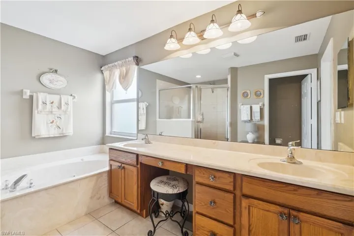 Bathroom with tile patterned floors, vanity, and independent shower and bath