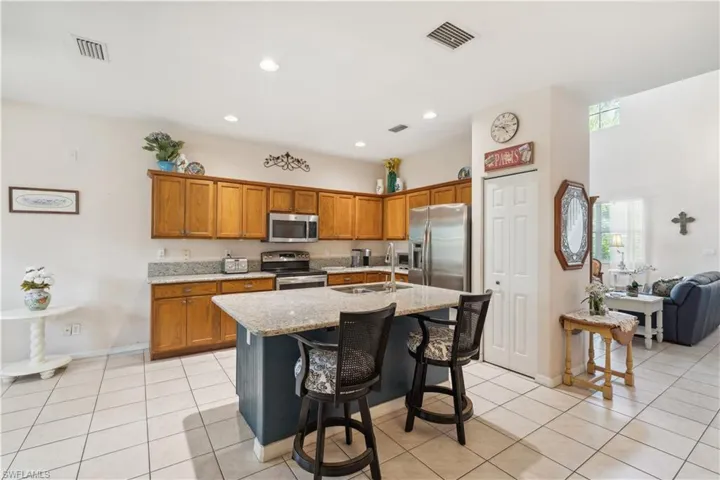 Kitchen featuring a kitchen bar, sink, an island with sink, and appliances with stainless steel finishes