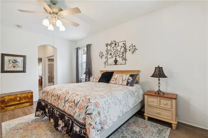 Bedroom featuring connected bathroom, ceiling fan, and hardwood / wood-style flooring