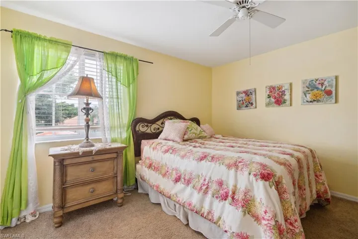 Carpeted bedroom featuring ceiling fan