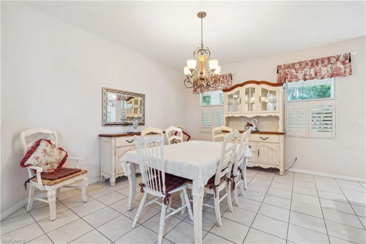 Dining area with a notable chandelier and light tile patterned floors
