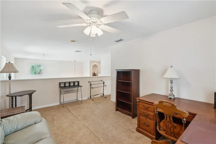 Carpeted office space featuring ceiling fan