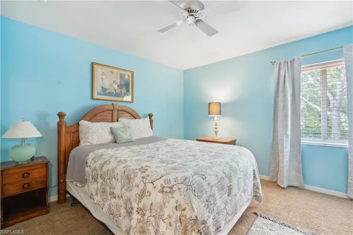 Carpeted bedroom featuring ceiling fan
