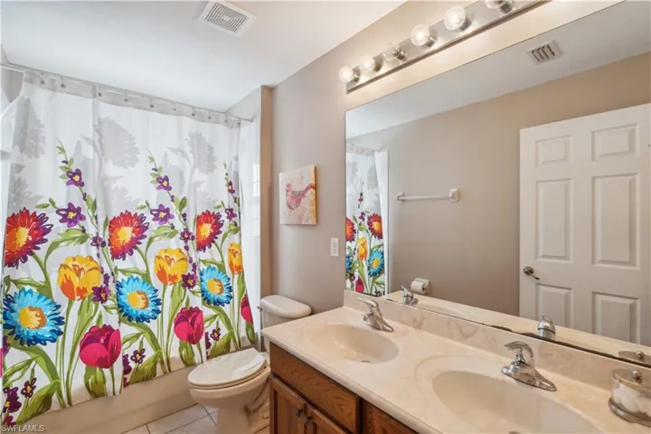 Full bathroom featuring tile patterned floors, vanity, shower / bath combo, and toilet