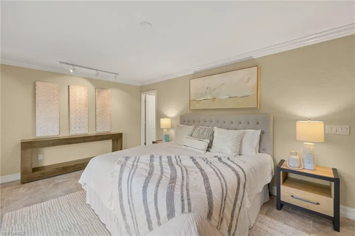 Large primary bedroom overlooking lush landscaping