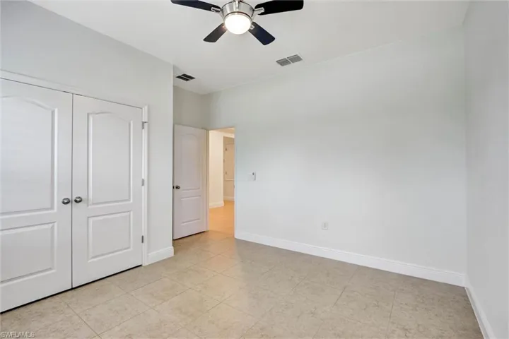 Interior room featuring tile flooring, white walls, and a ceiling fan