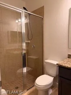 Second masters bathroom  Tiled shower enclosure with clear glass door, chrome fixtures, and built-in shelving