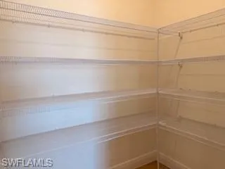 Corner storage space featuring multiple levels of white wire shelving, large butler pantry in kitche