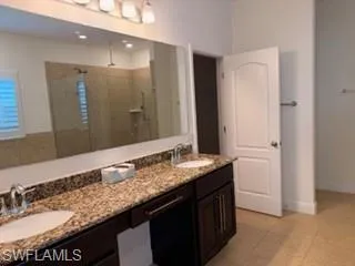 Double vanity with integrated sinks and a stone-finish countertop