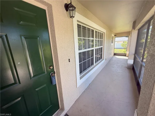 Property entrance featuring a sunroom and stucco siding
