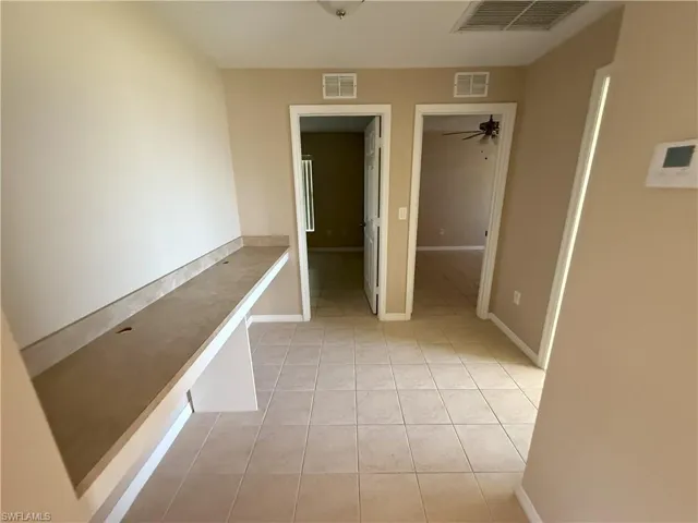 Corridor with light tile patterned floors and baseboards