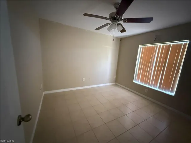 Tiled spare room with baseboards and ceiling fan