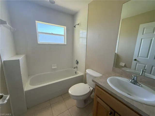 Full bathroom with shower / bath combination, vanity, and light tile patterned floors