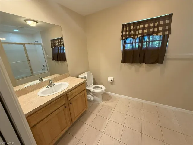 Full bath with vanity and light tile patterned flooring