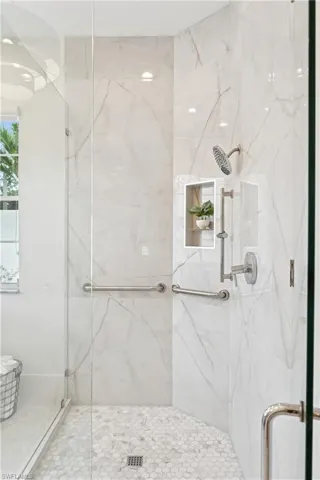 Full bath with a marble finish shower