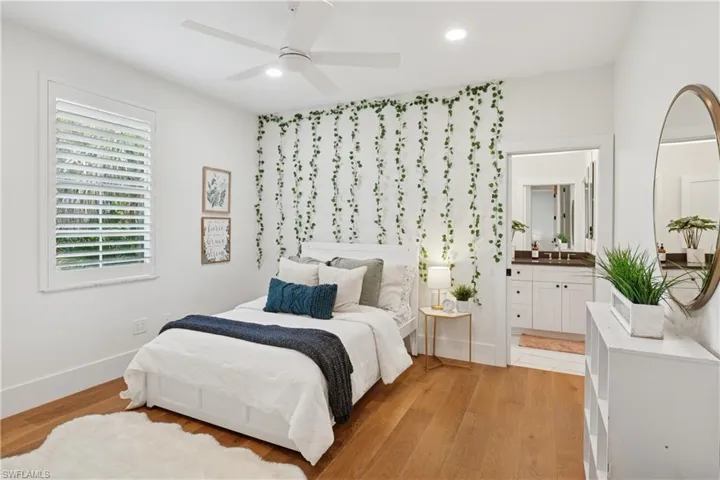 Bedroom featuring light wood-type flooring, recessed lighting, ensuite bathroom, baseboards, and a ceiling fan