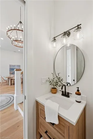 Bathroom featuring wood finished floors, vanity, a chandelier, recessed lighting, and ensuite bathroom