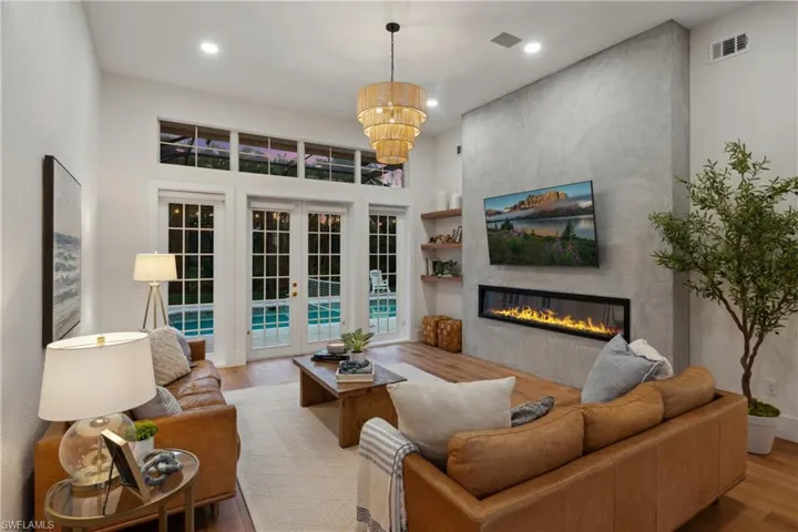 Living area with wood finished floors, a fireplace, a chandelier, and recessed lighting
