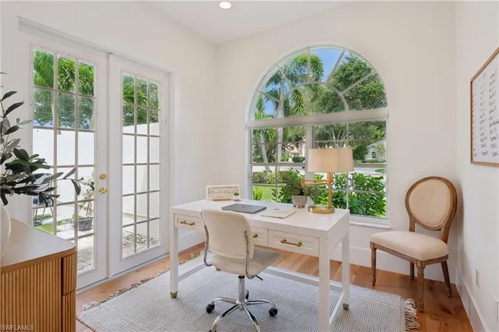 Office area with healthy amount of natural light, wood finished floors, and baseboards