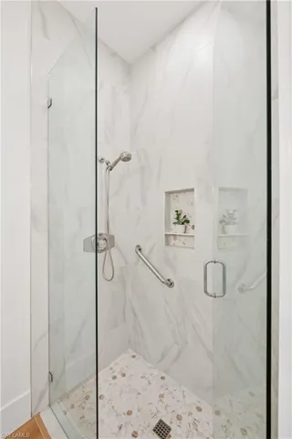 Full bath with a marble finish shower