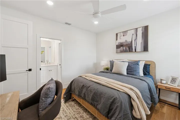 Bedroom featuring light wood-style flooring, recessed lighting, ensuite bath, a sink, and ceiling fan