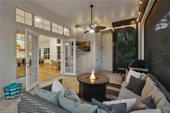 View of patio / terrace with french doors, an outdoor living space with a fire pit, and ceiling fan