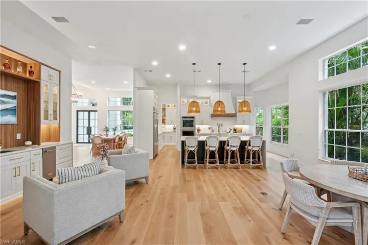 Living area featuring light wood-style floors, healthy amount of natural light, recessed lighting, and a chandelier