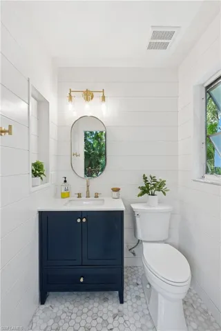 Pool Bathroom with toilet, vanity, and tile patterned flooring