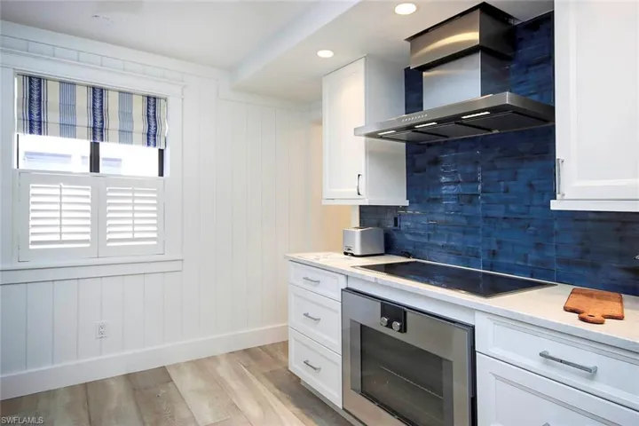 Kitchen featuring backsplash, Gaggenau luxury appliances - wall oven, wall chimney range hood, with electric cooktop