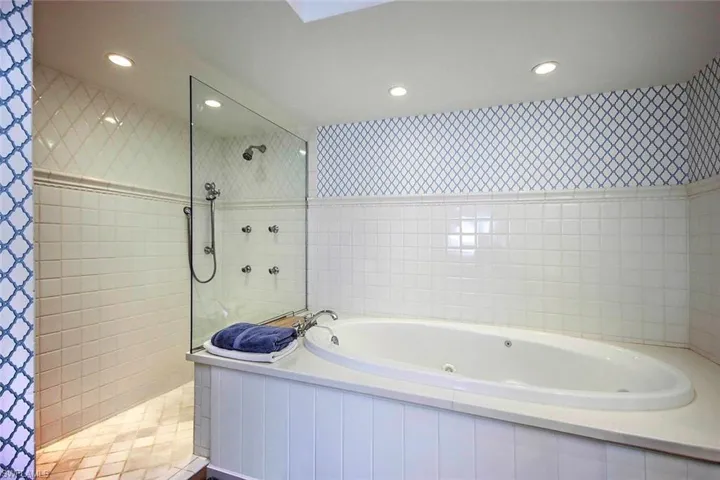 A built-in jetted tub, the shower has multiple body jets along with a handheld showerhead, enhancing functionality and comfort.