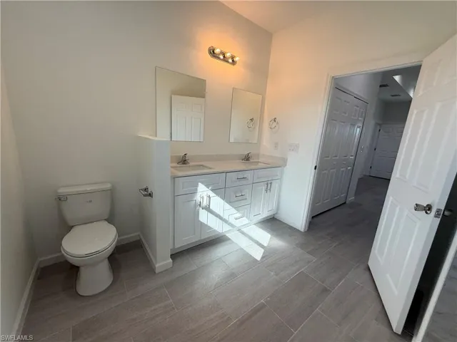 Bathroom with double vanity and baseboards