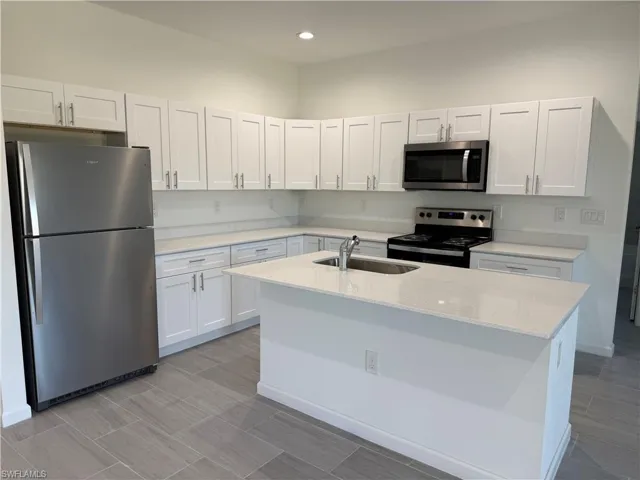 Kitchen featuring appliances with stainless steel finishes, white cabinetry, and recessed lighting