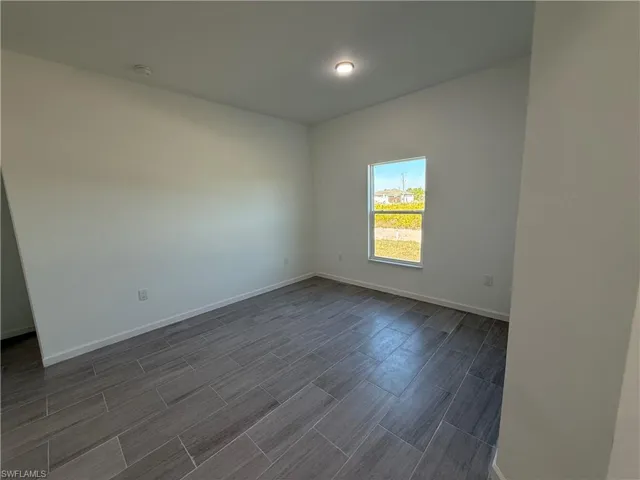 Empty room with baseboards and wood finish floors