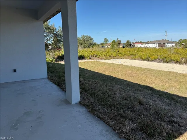 View of grassy yard with a patio area
