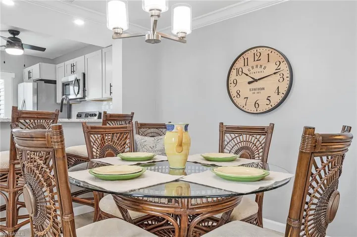 Dining area featuring crown molding and ceiling fan with notable chandelier
