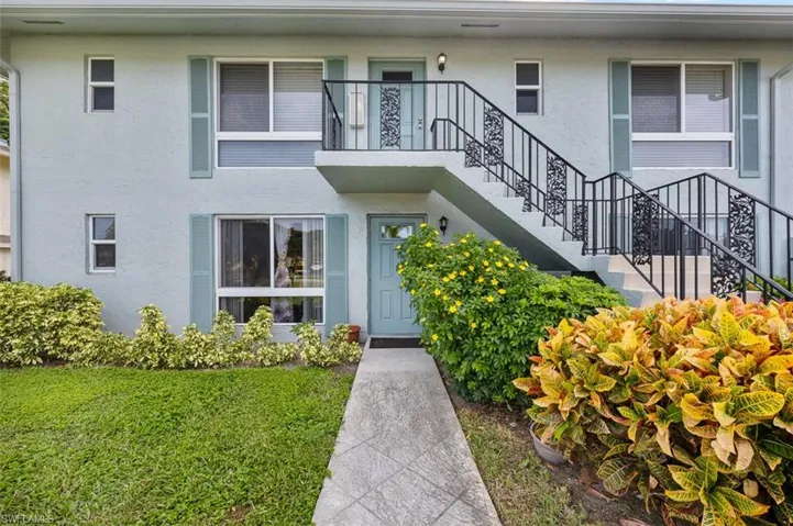 Doorway to property featuring stucco siding and a lawn