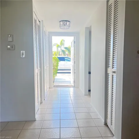 Doorway to outside featuring tile patterned floors and baseboards