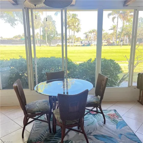 Sunroom / solarium with outdoor dining area and a ceiling fan