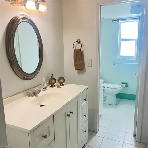 Bathroom with light tile patterned flooring and vanity