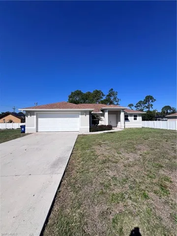 Ranch-style home featuring an attached garage and driveway