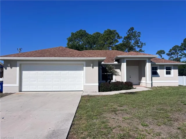 Ranch-style home featuring stucco siding, concrete driveway, a garage, and a front yard