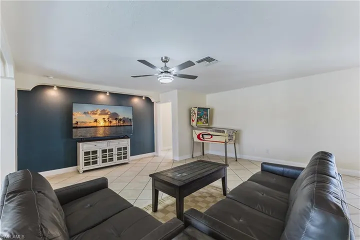 Living area with ceiling fan and light tile patterned flooring