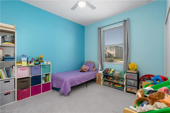 Carpeted bedroom featuring ceiling fan