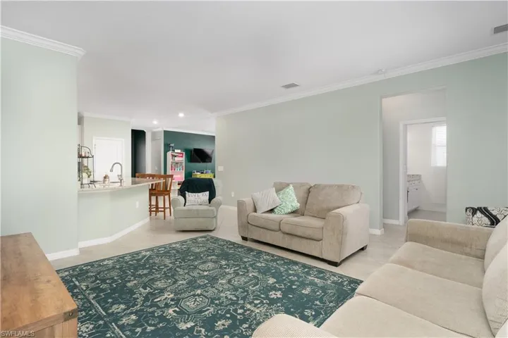 Tiled living room with crown molding and sink