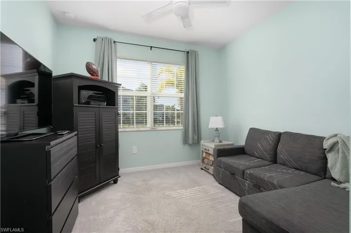 Carpeted living room with ceiling fan