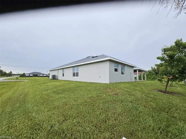 View of side of property featuring a lawn