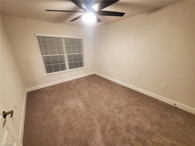 Empty room with carpet and ceiling fan