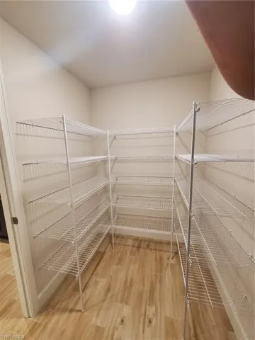 Spacious closet with hardwood / wood-style flooring