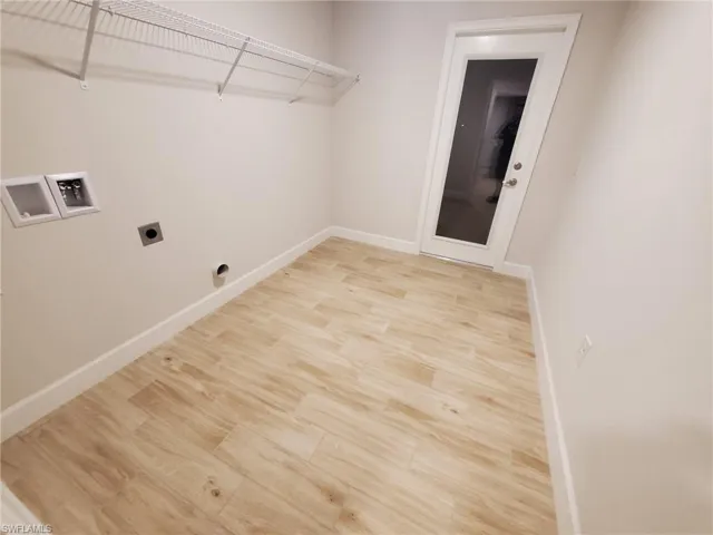 Laundry room featuring washer hookup, electric dryer hookup, and light hardwood / wood-style flooring